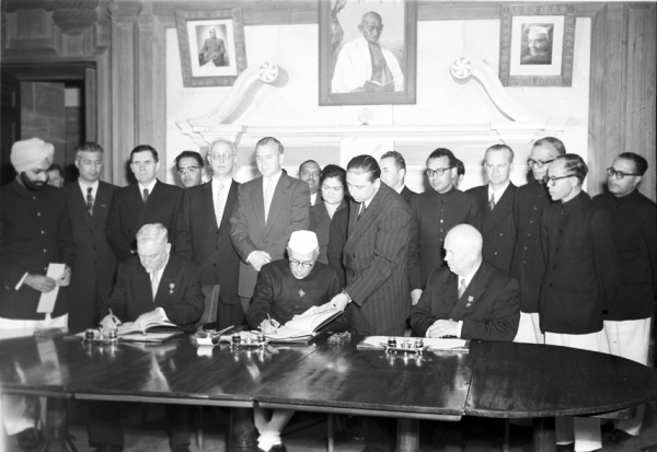 Ph.Studio/Dec,1955,A10z(iv) Prime Minister, Shri Jawaharlal Nehru and H.E. Mr. Bulganin signing an agreement in the presence of distinguished men from diplomatic circles at New Delhi. H.E. Mr. Khrushchev is on extreme right (sitting) on December 13, 1955.